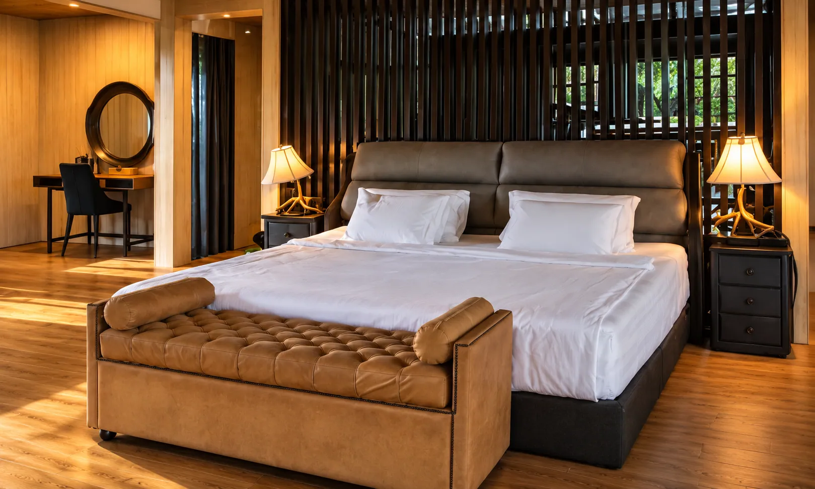 A king bedroom with a leather bench and dressing table